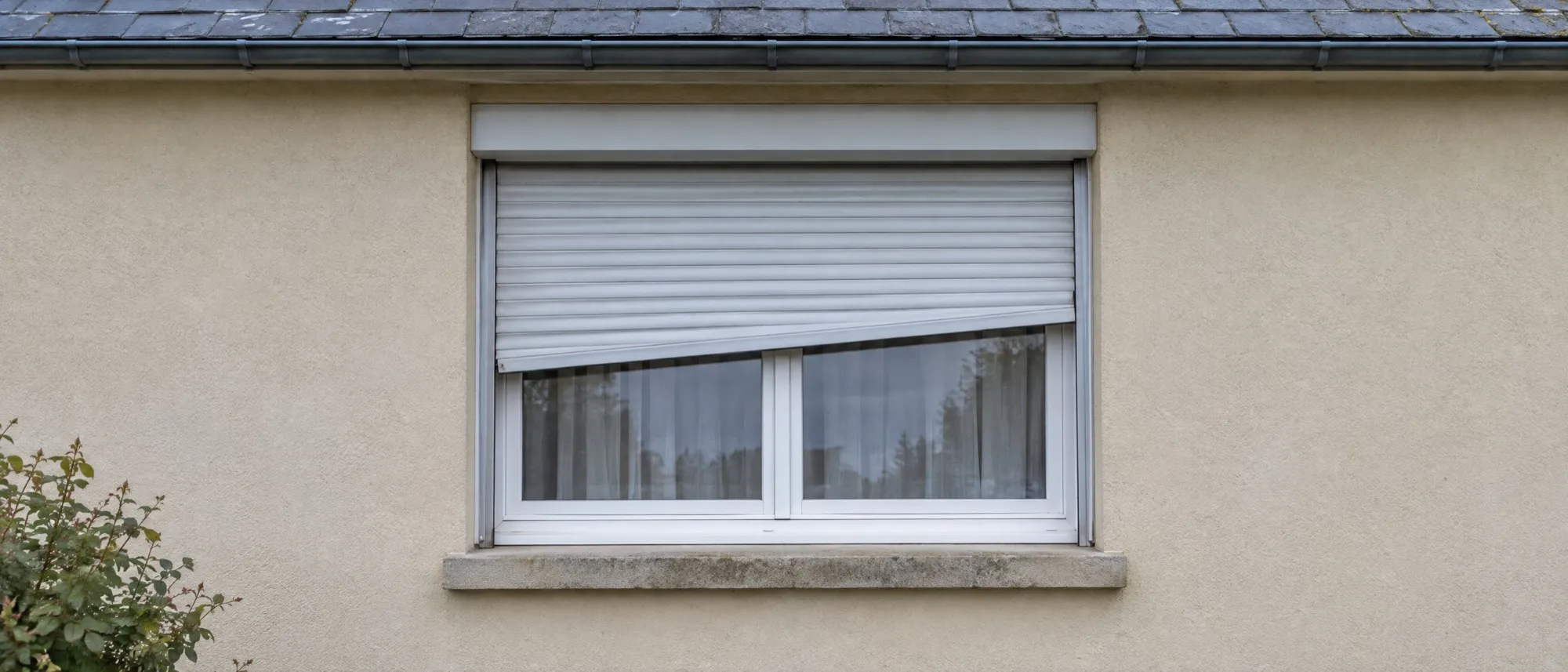 Volet roulant bloqué de travers à mi-hauteur sur une façade